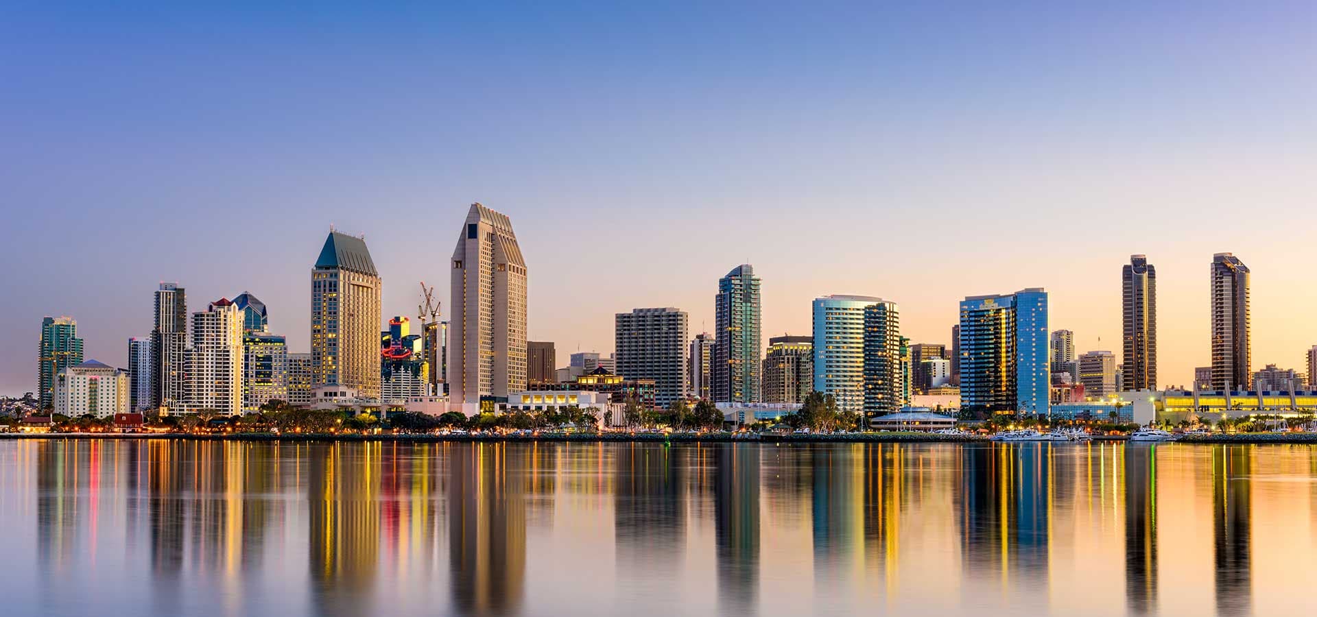 City skyline at dusk with waterfront buildings